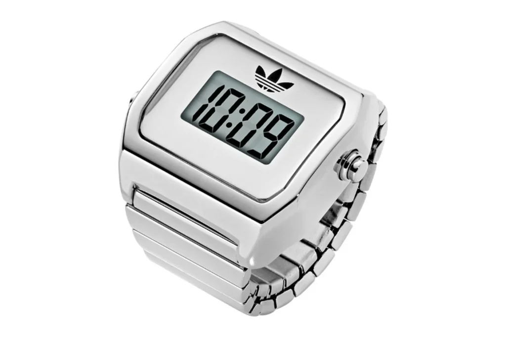 Three-quarter view of a silver-tone adidas Digital Two ring with expansion band and digital LCD display on white background.