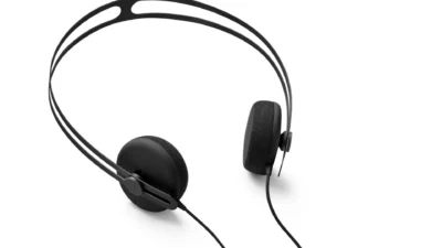 AIAIAI Tracks on-ear headphones three-quarter view on white: thin split headband, circular pads, AIAIAI branding on slider,…