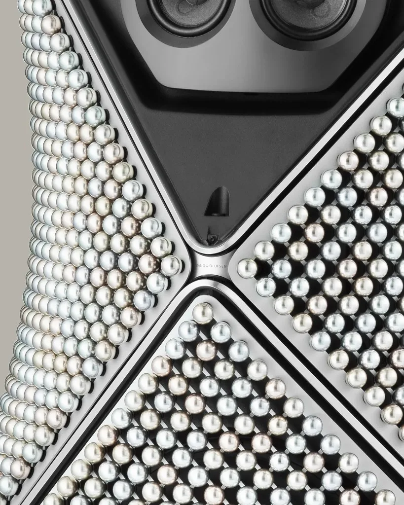 Macro detail of Beolab 90 Zenith Edition anodized spheres and engraved Bang Olufsen branding at a panel junction.