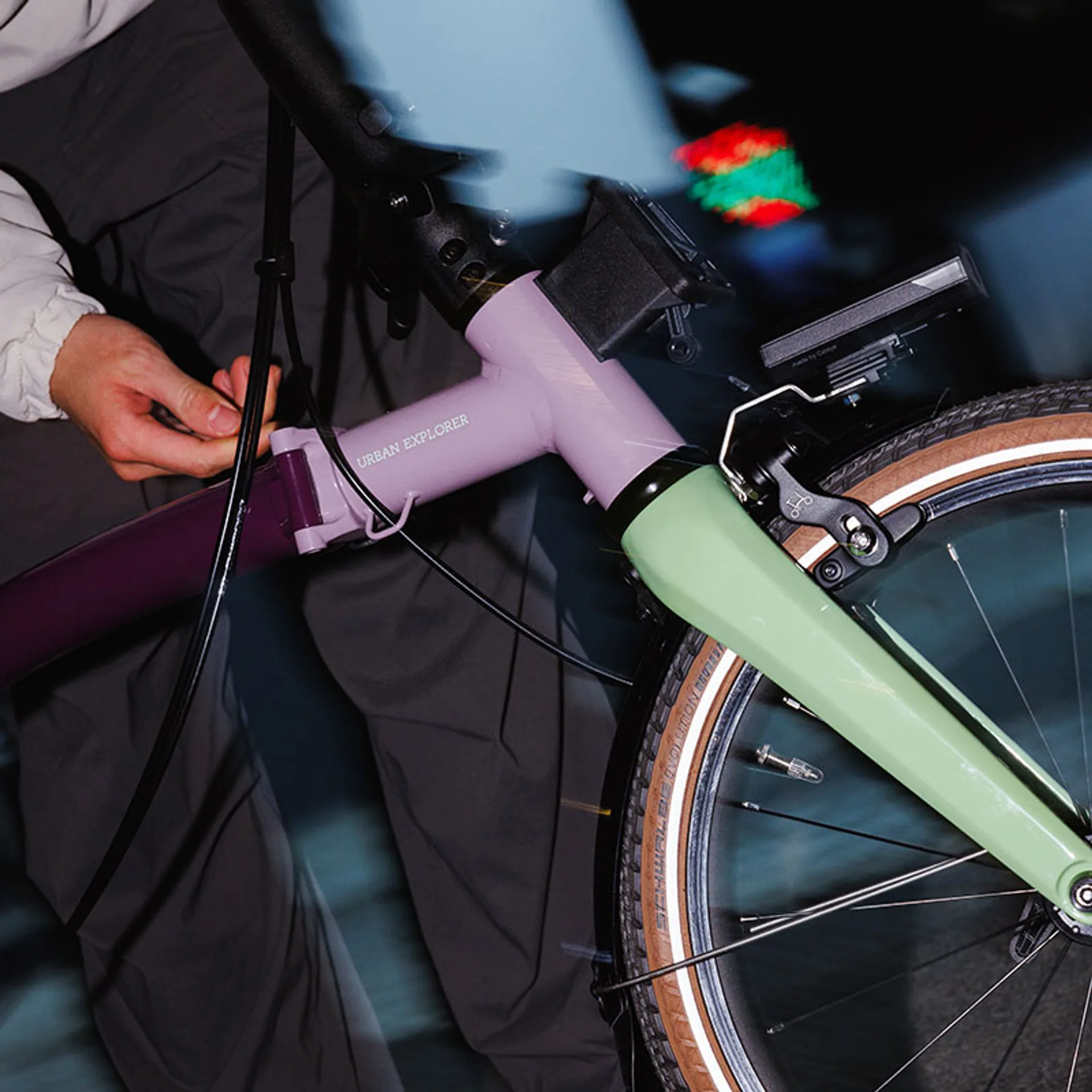 Brompton P Line Asia-Exclusive front detail at night: Urban Explorer lettering on split purple frame, sage green fork, Schwa…
