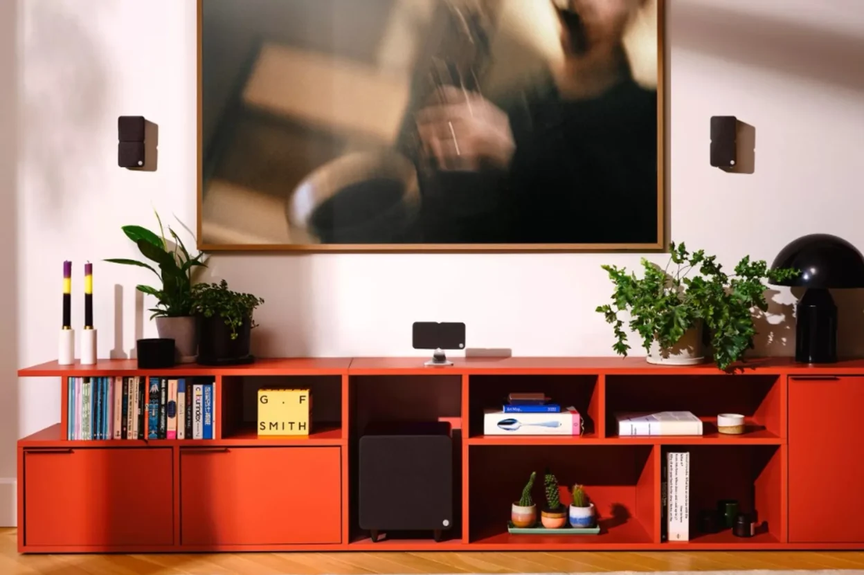 Cambridge Audio Minx black satellite speakers and subwoofer in a modern living room with a red modular sideboard, plants, bo…