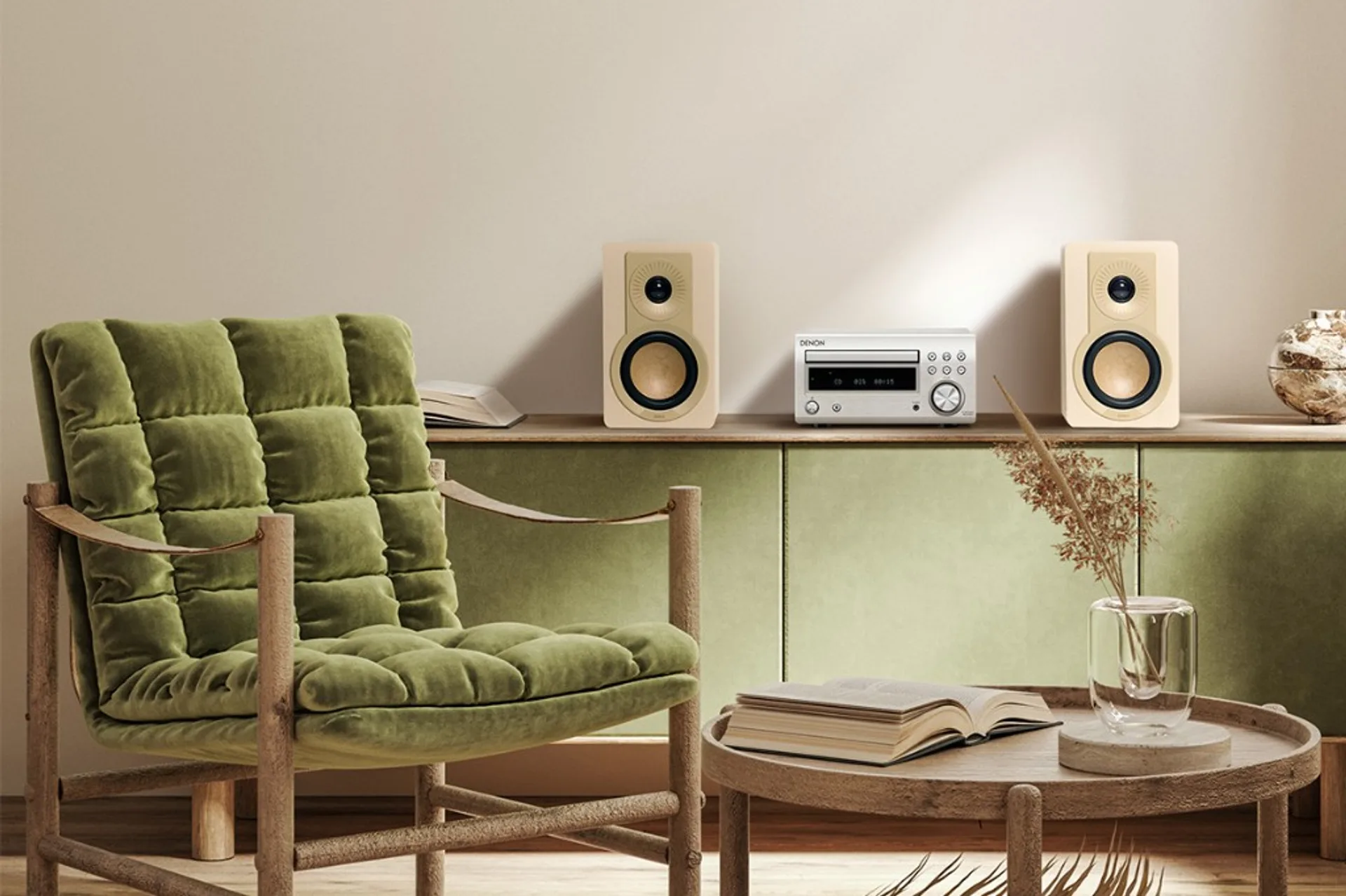 Cream Dali Kupid bookshelf speakers flanking a silver Denon receiver on a green and wood console in a modern living room.
