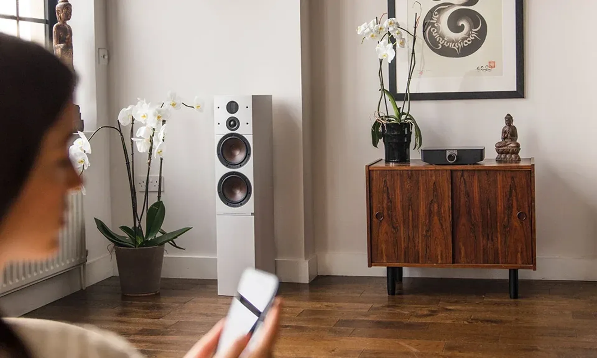 Living room wireless active speaker setup with compact hub and smartphone control.