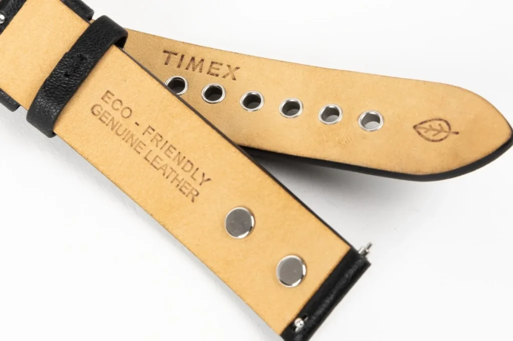 Underside of Dime x Timex T80 black leather straps: tan lining, Timex stamp, eco-friendly genuine leather text, grommets and…