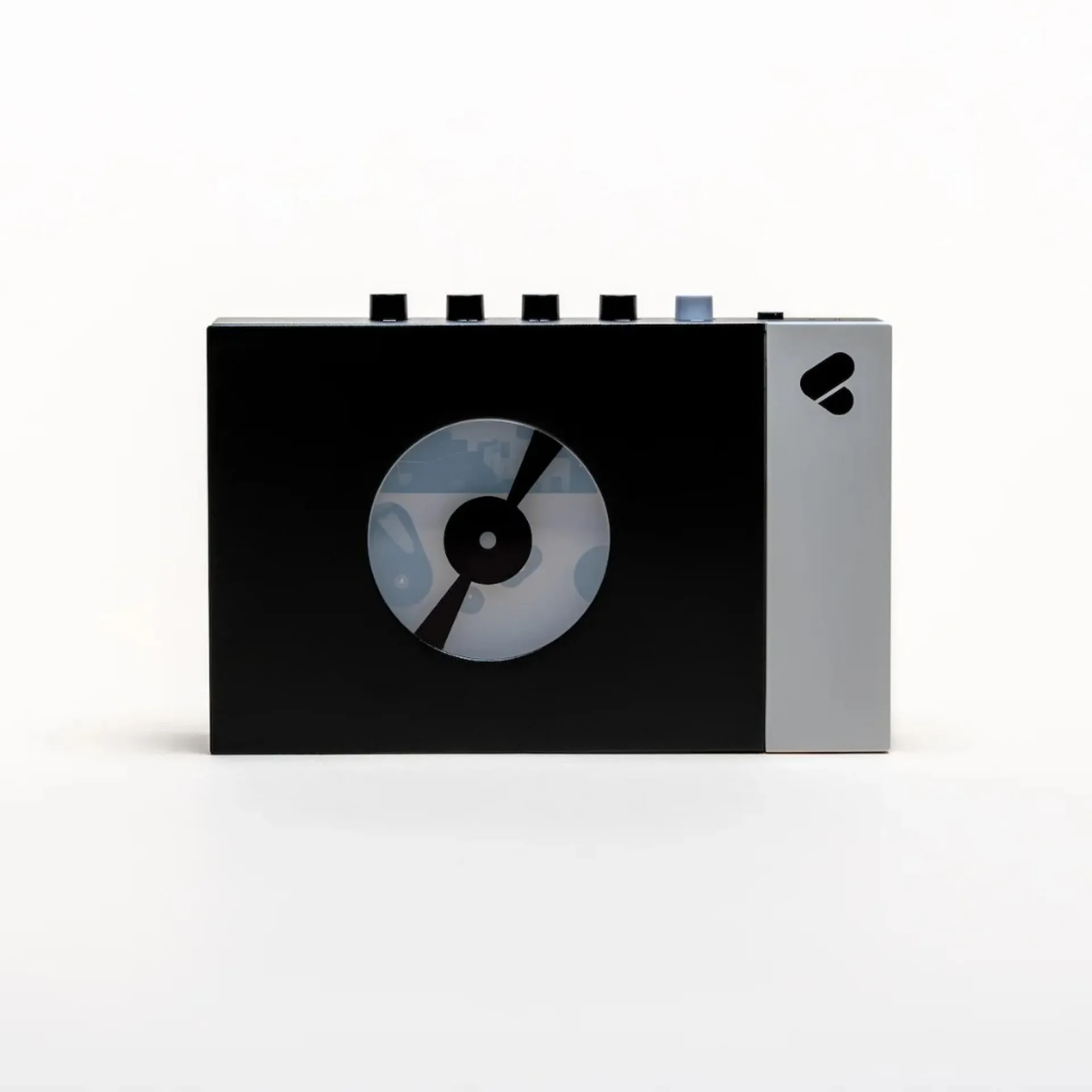 Front view Discogs x We Are Rewind portable cassette player: matte black face, circular tape window, silver accent strip with logo, top transport buttons.