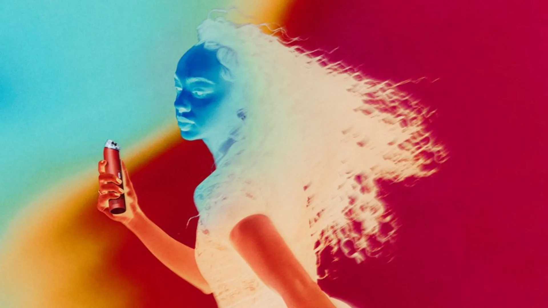 Stylized lifestyle shot: woman in profile holds red Dyson HushJet Mini Cool, thermal-map style cool blues and warm oranges, hair flowing in breeze.