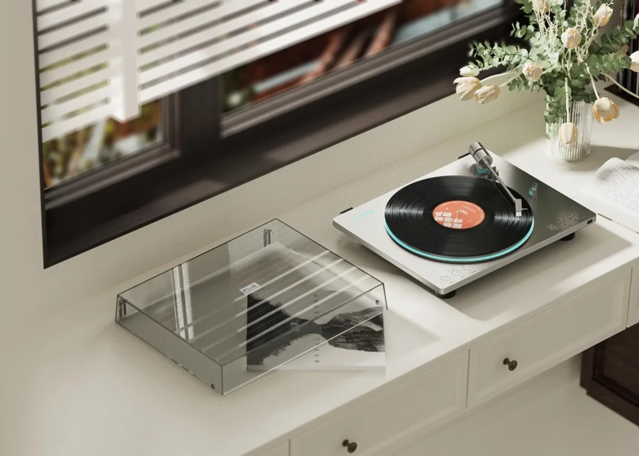 FiiO TT13 automatic turntable placed on a white console in a living room, top perspective with dust cover beside it.