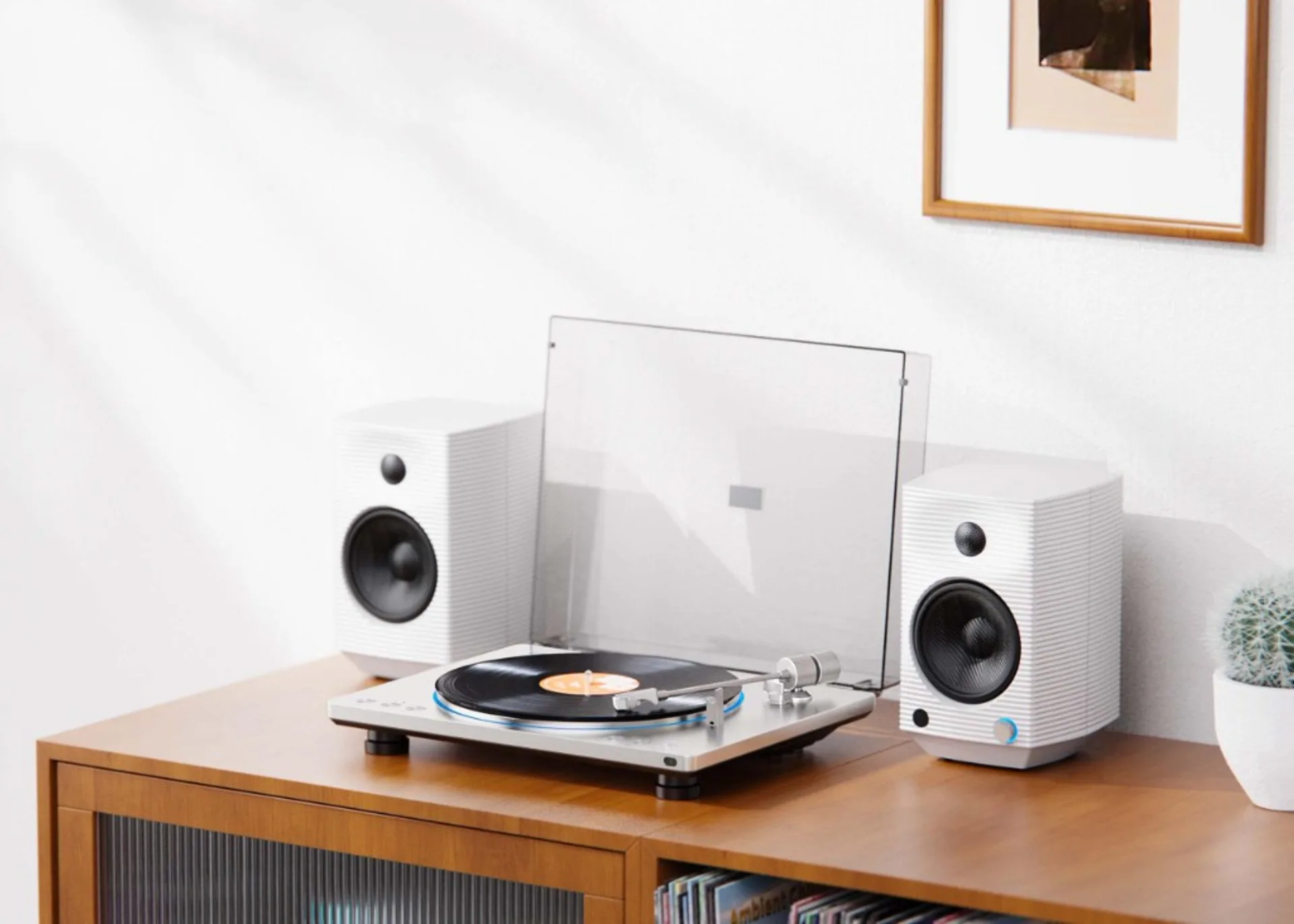FiiO TT13 turntable setup with two white bookshelf speakers and raised dust cover on a wooden cabinet.