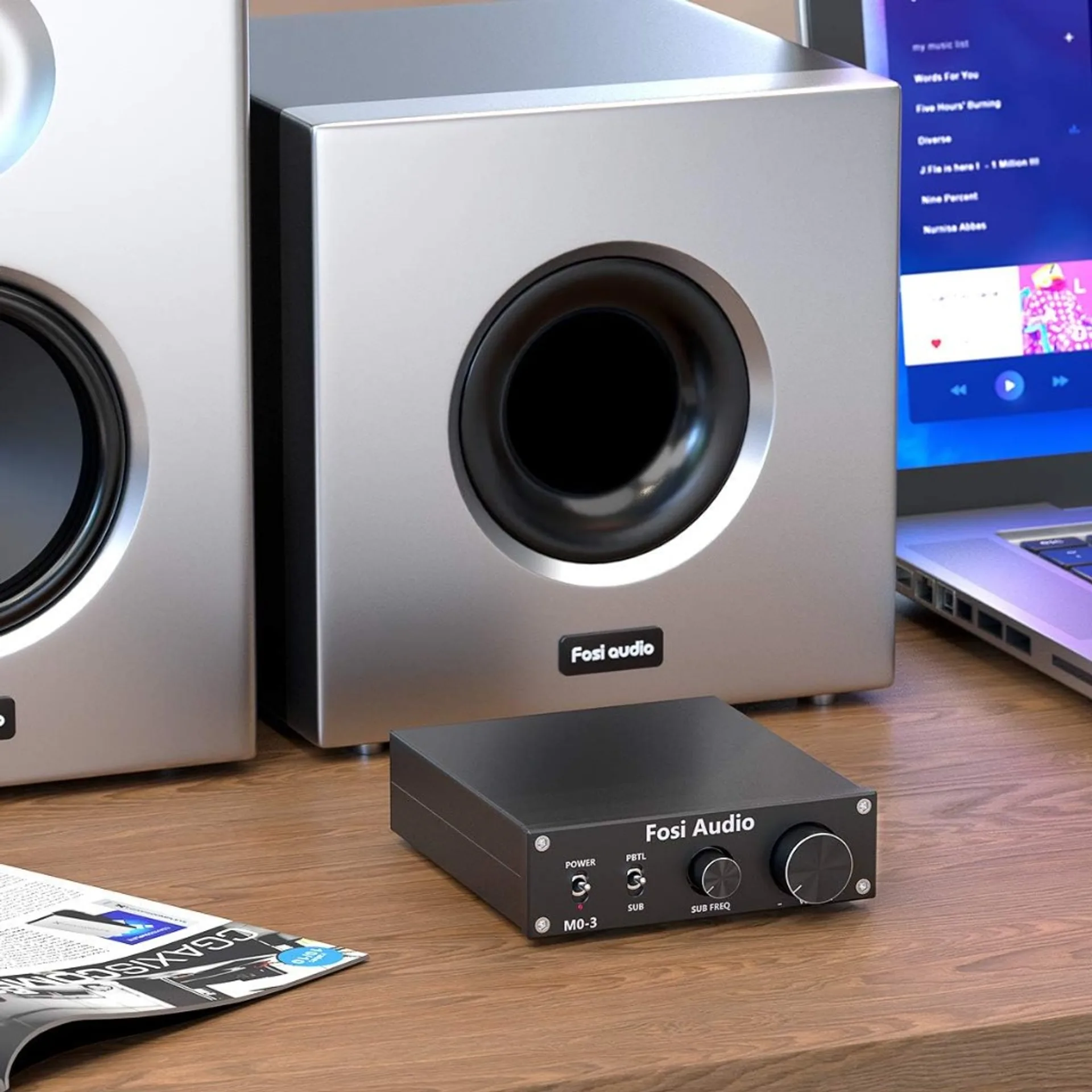 Fosi Audio M03 compact black subwoofer amp on wood desk with power and PBTL or SUB toggle, sub freq and volume knobs; silver…