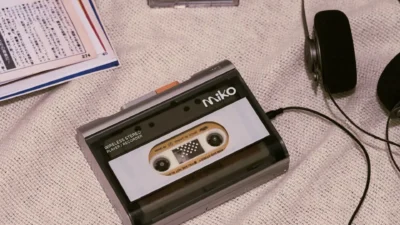 Gadhouse Miko wireless stereo cassette player on textured fabric with headphones, cassette cases, mint accent and magazine,…