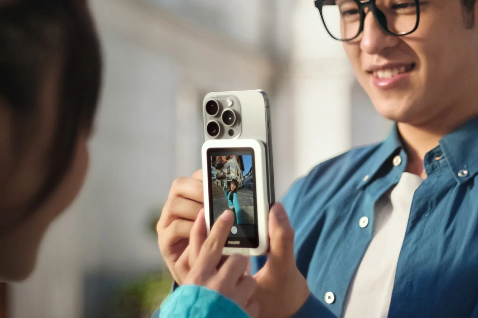 Người dùng Insta360 Snap ngoài trời: màn hình phụ hiển thị khung cảnh khi chụp bằng camera sau điện thoại