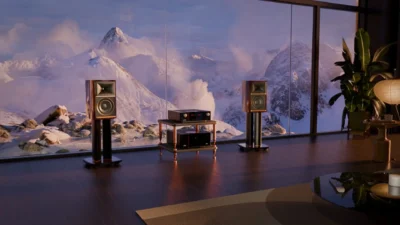 JBL Summit Ama hi-fi system with walnut stand-mount speakers flanking a copper-legged rack and amplifiers in a luxury living…