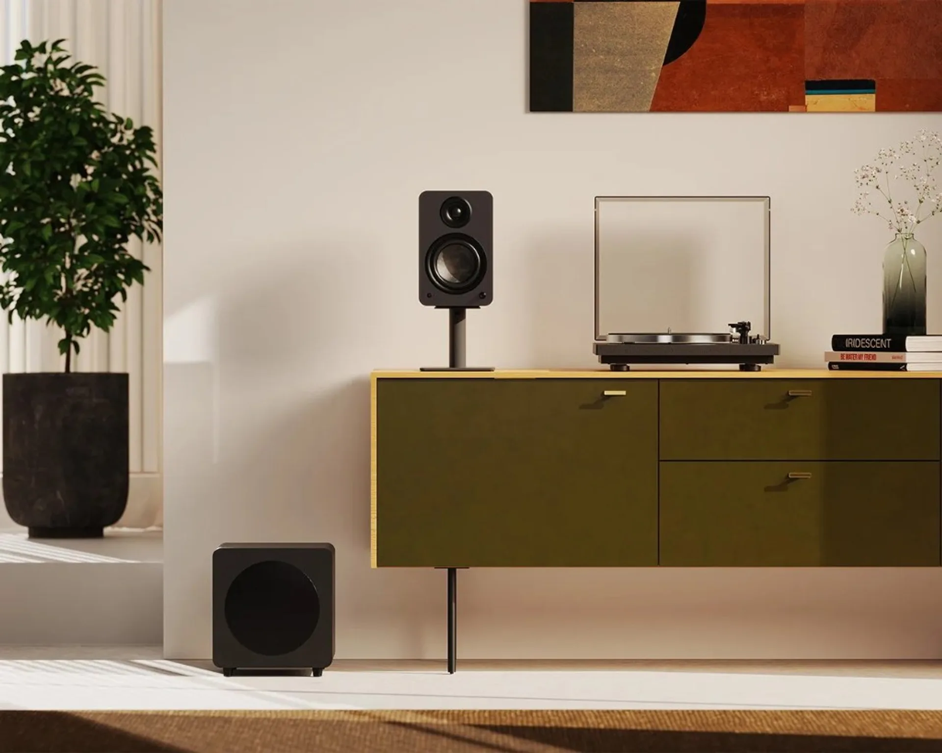 Kanto black bookshelf speaker on stand with matching subwoofer and turntable on olive-green credenza, bright minimalist interior.