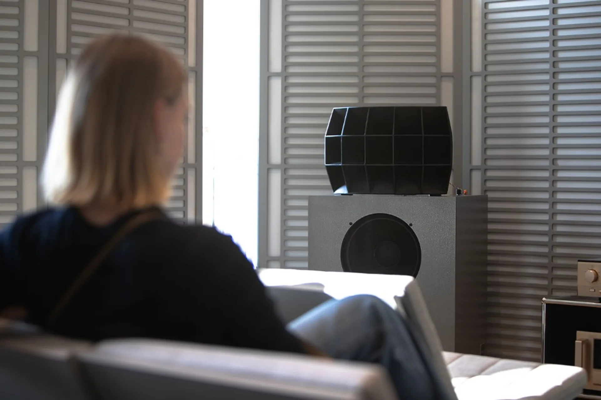 Lifestyle shot of the Klipsch Ojas kO-R2 with multicell horn and large woofer in a bright minimalist listening room with a l…