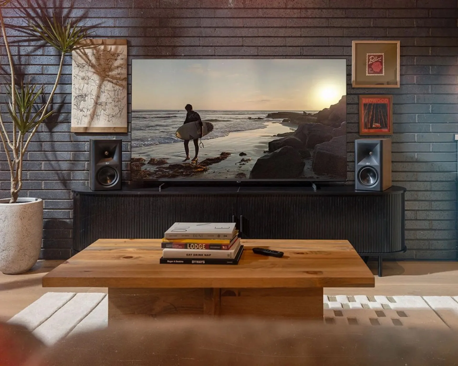 TV cảnh biển trên tường gạch đen, loa bookshelf Klipsch horn hai bên kệ console đen