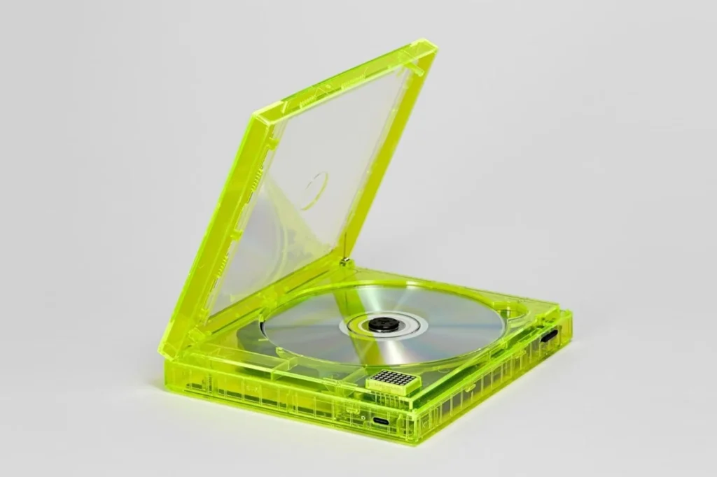 Máy CD km5 vỏ vàng neon trong, nắp mở có đĩa CD, cổng USB-C và màn LED
