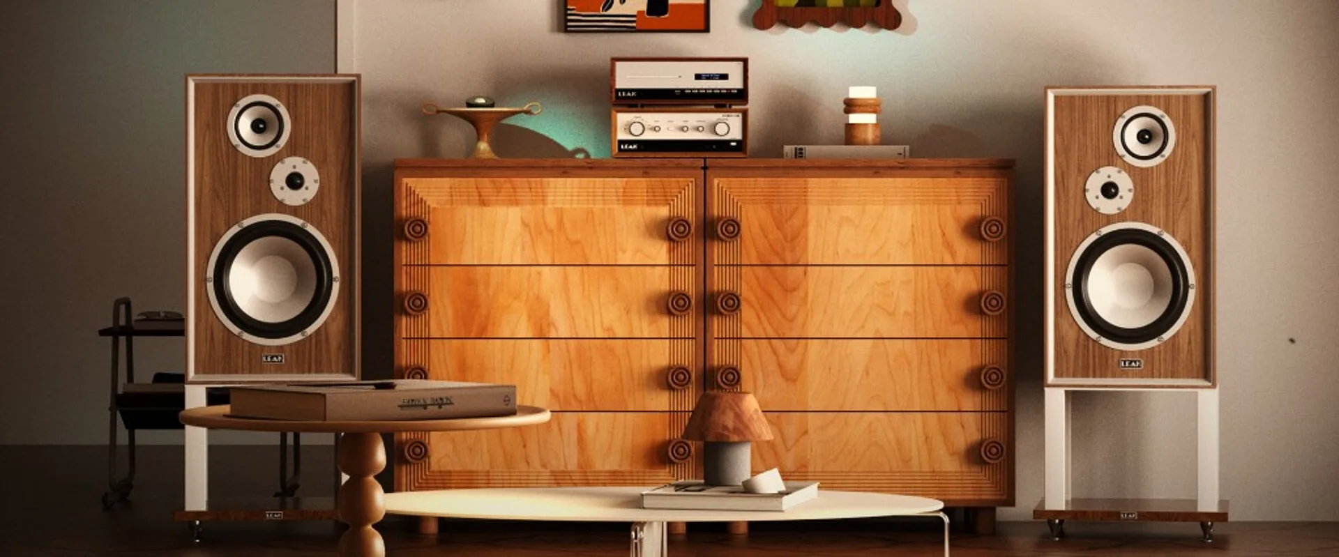 Wide lifestyle shot: Leak TruStream and amplifier stack on light wood sideboard flanked by large Leak Sandwich floorstanding…