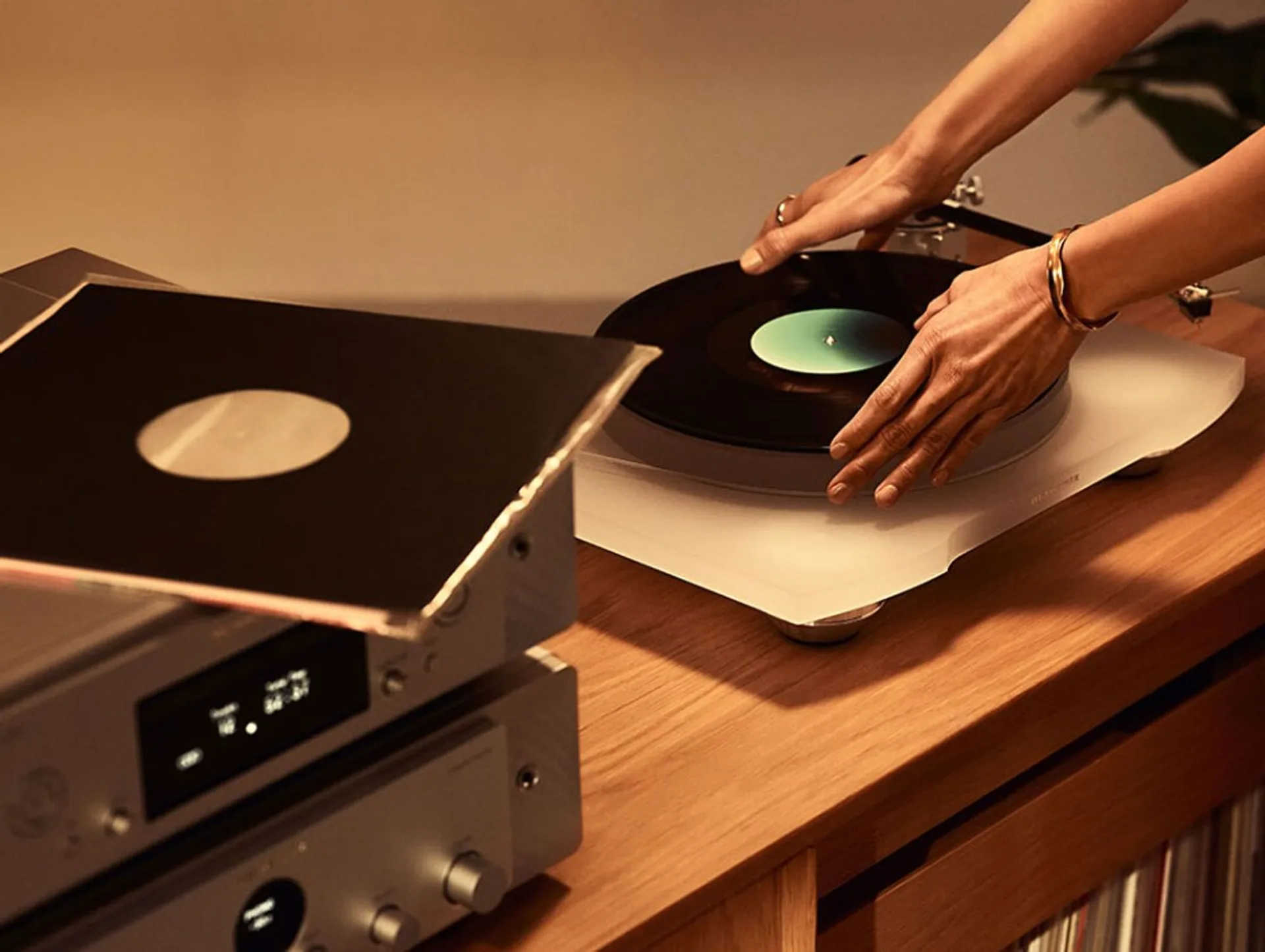 Đặt đĩa than lên Marantz TT-15S1 acrylic trắng cạnh stack Marantz và đĩa vinyl