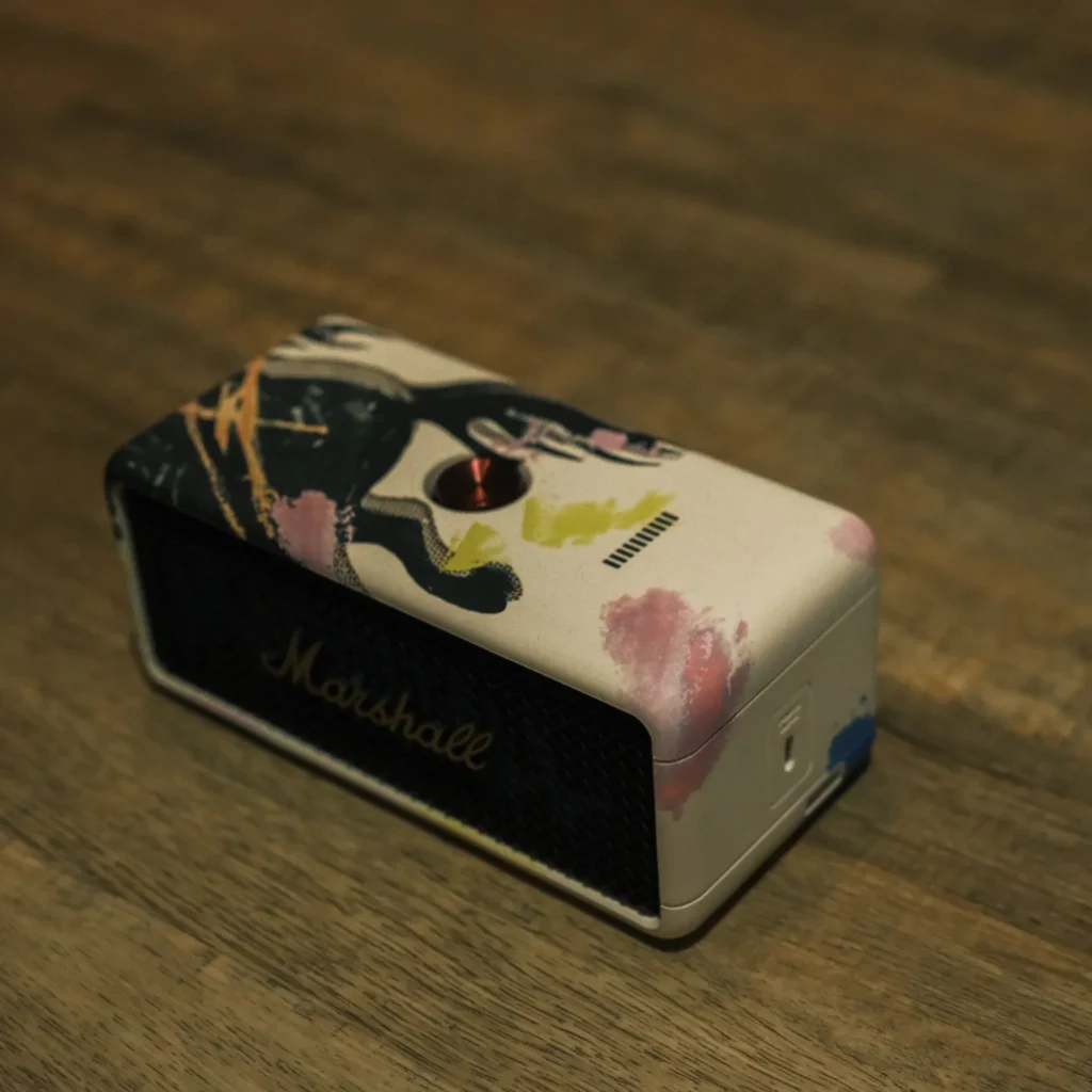 Marshall Emberton III Lunar New Year 2026 limited edition on dark rustic wood: hand-finished art wrap, gold logo on black grille, red multi-way control.