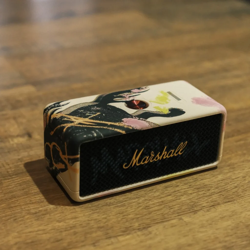 Marshall Emberton III Lunar New Year 2026 on a wooden table: collector art shell, gold Marshall script on grille, brass control knob.