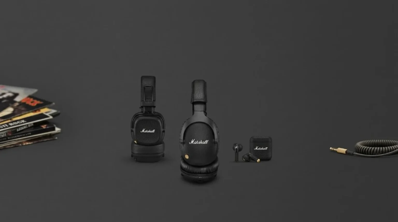 Marshall on-ear and over-ear headphones, true wireless earbuds and case on charcoal grey; vinyl stack left, coiled cable wit…