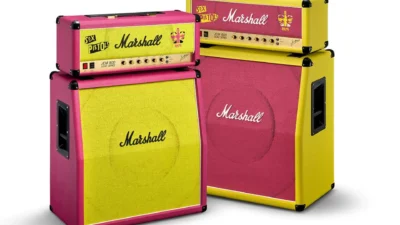 Two Marshall x Sex Pistols JCM800 stacks side by side: one pink chassis with yellow grille, one yellow chassis with pink gri…