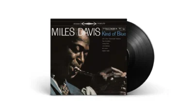 Miles Davis Kind of Blue album sleeve with black vinyl LP partially slid out on white background, Columbia stereo fidelity c…