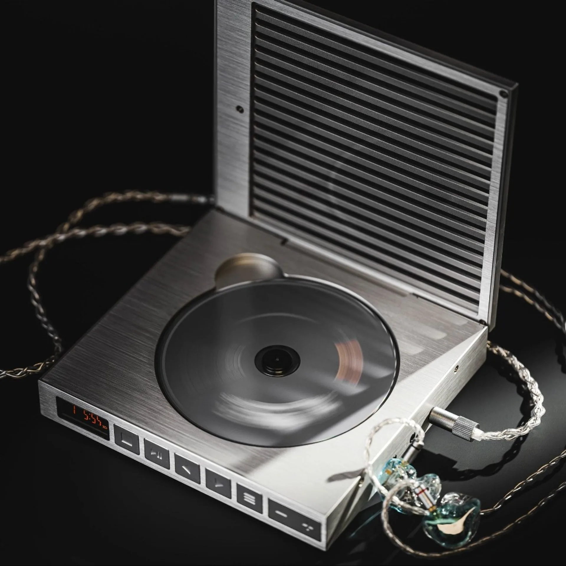 Moondrop DISCDREAM2 Ultra portable CD player, lid open with spinning disc and transparent IEMs on a dark surface.