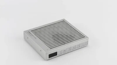 Moondrop DISCDREAM2 Ultra portable CD player three-quarter view on white background with top slats and front controls.