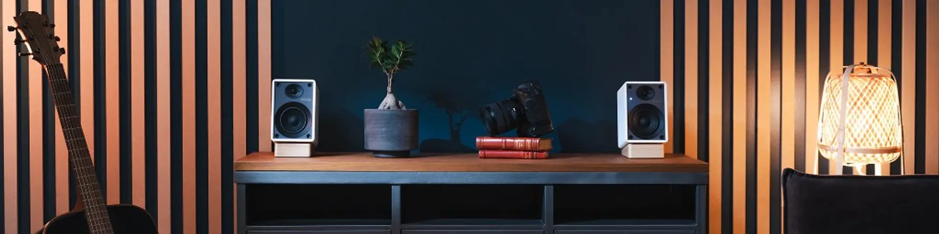 Panoramic lifestyle: white Onkyo Creator GX-10DB powered monitors on wooden stands at ends of a long credenza, bonsai, books…