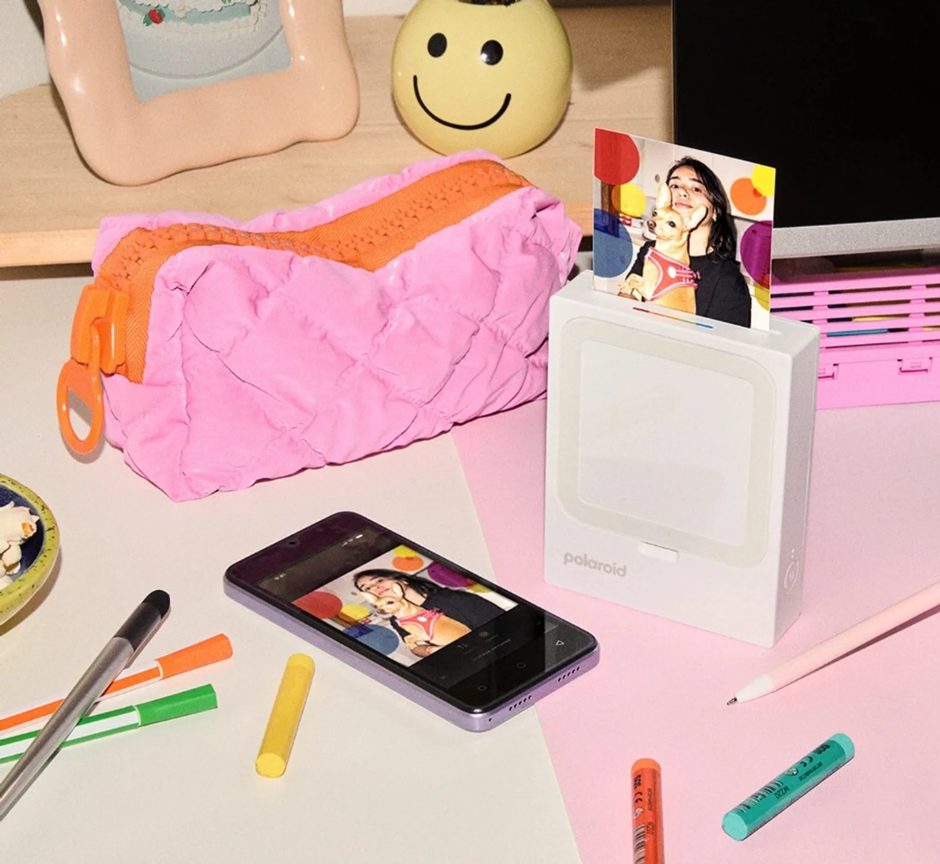 Polaroid Hi-Print 3x3 lifestyle setup with printed photo output, smartphone editing app preview, and desk stationery.