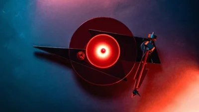 Top-down view of Pro-Ject AC/DC limited edition turntable: lightning-bolt plinth and glowing red glass platter under blue an…