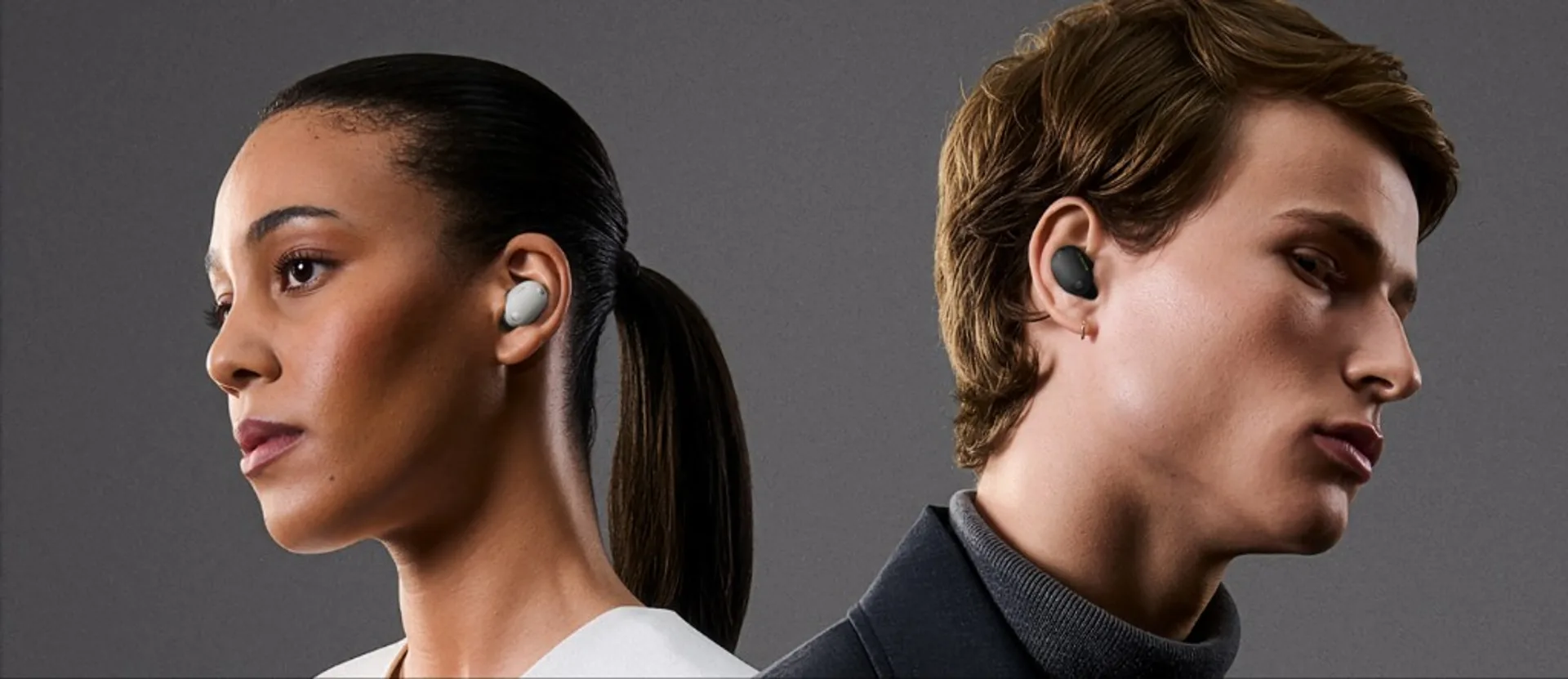 Person wearing Sony WF-1000XM6 earbuds while seated in an airport lounge with carry-on luggage nearby.