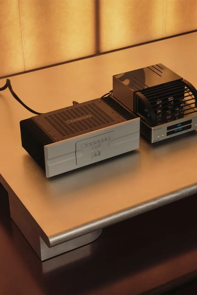 Bryston 3B3 power amplifier and PrimaLuna EvoLution tube DAC on a brushed metal rack, warm ambient light.
