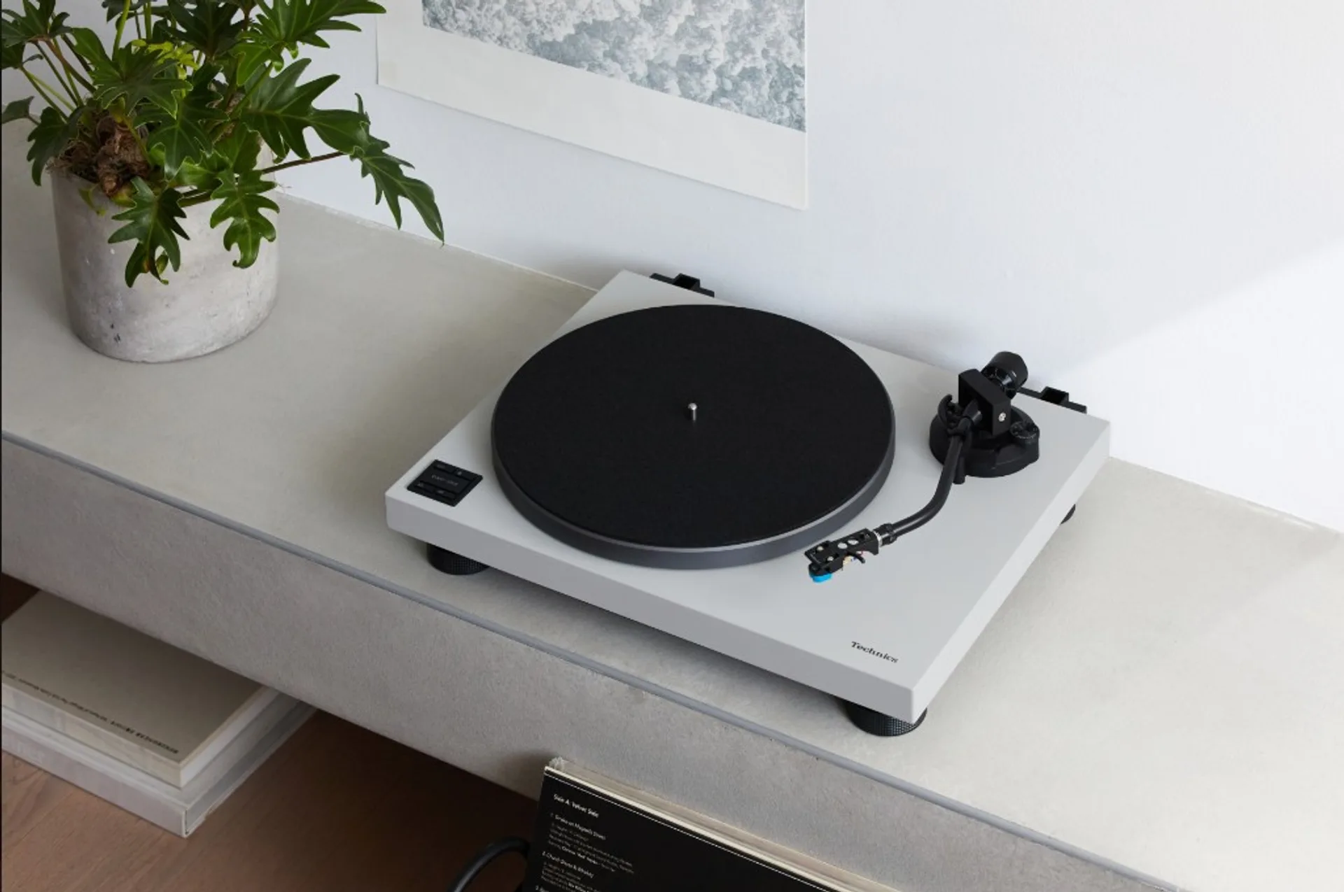 Technics SL-50C turntable in white finish on a home shelf.