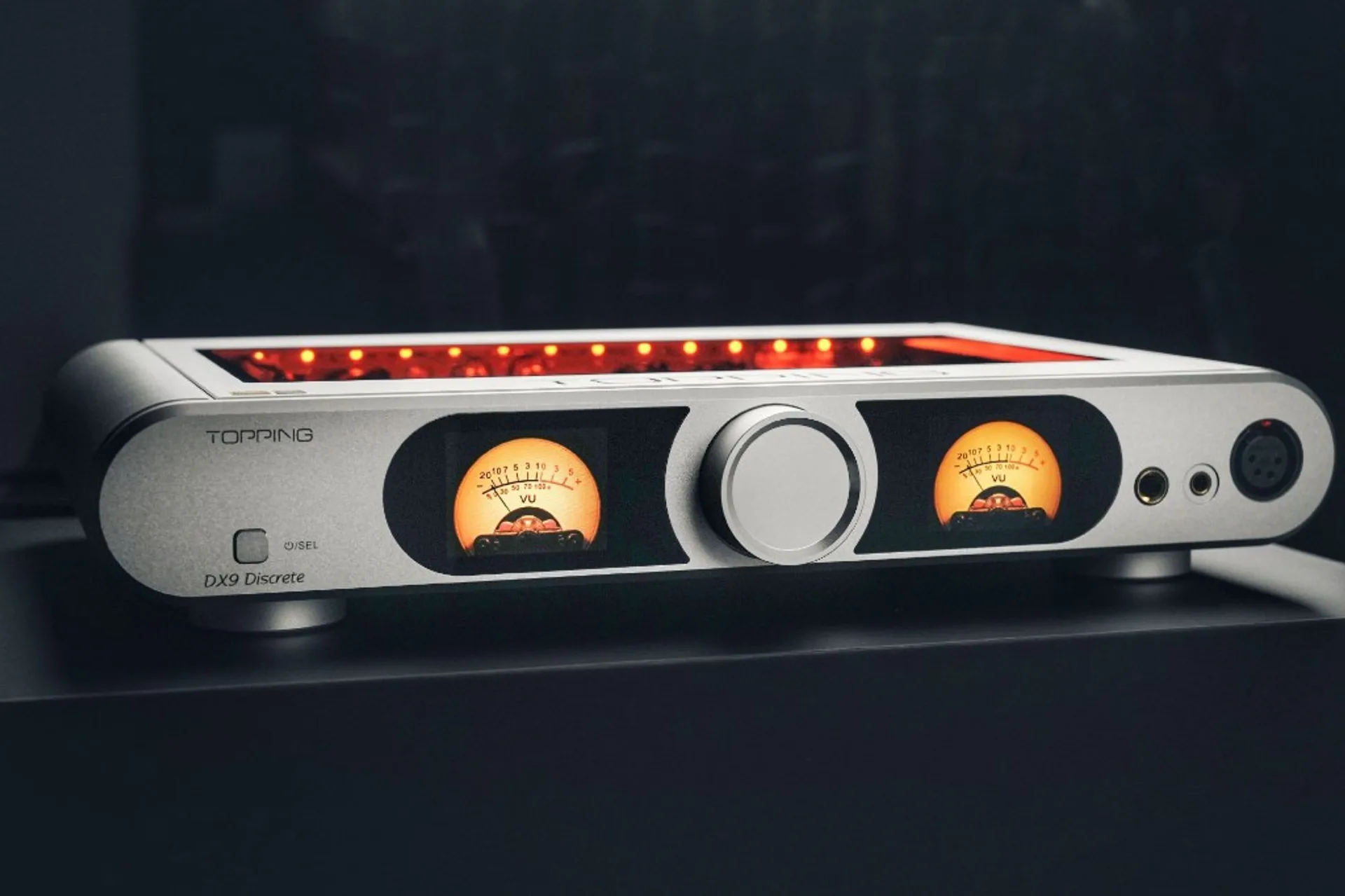 Topping DX9 Discrete front view with illuminated VU-style display graphics and central control knob.