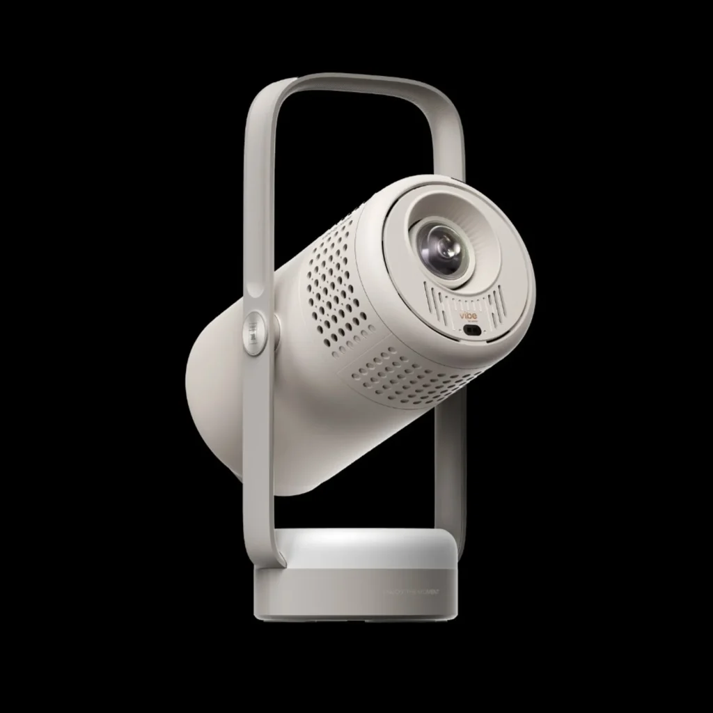 XGIMI Vibe One portable projector at an angle showing lens, vibe branding, cooling vents and integrated handle stand on blac…