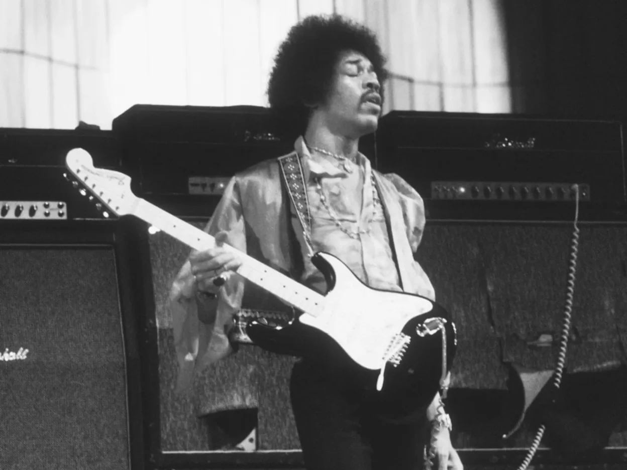 Musician with acoustic guitar beside Marshall x Hendrix limited edition speaker with purple velvet and psychedelic grille, s…