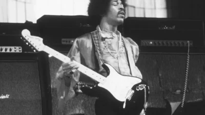 Musician with acoustic guitar beside Marshall x Hendrix limited edition speaker with purple velvet and psychedelic grille, s…
