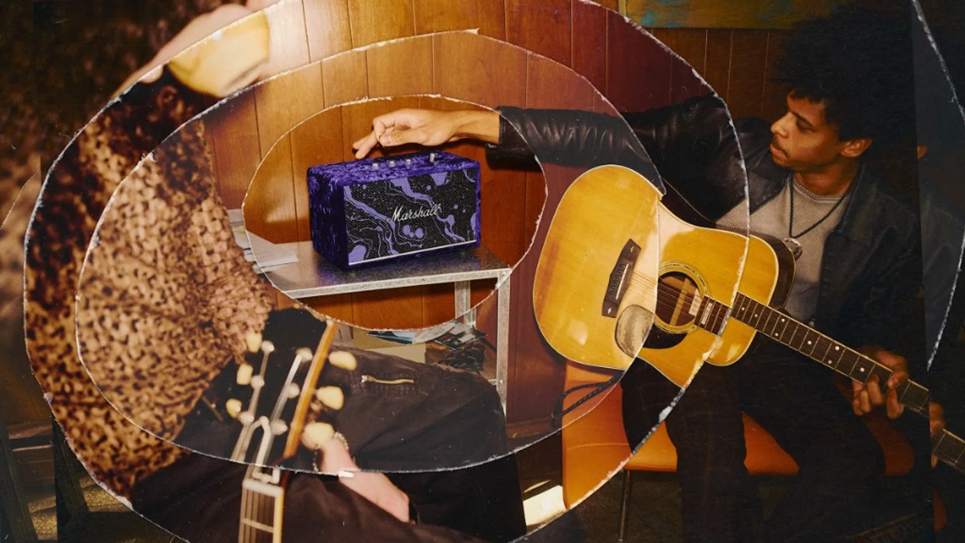 Musician carrying a Marshall guitar amplifier head with purple-accented control panel up a dark wooden staircase near a green exit sign.