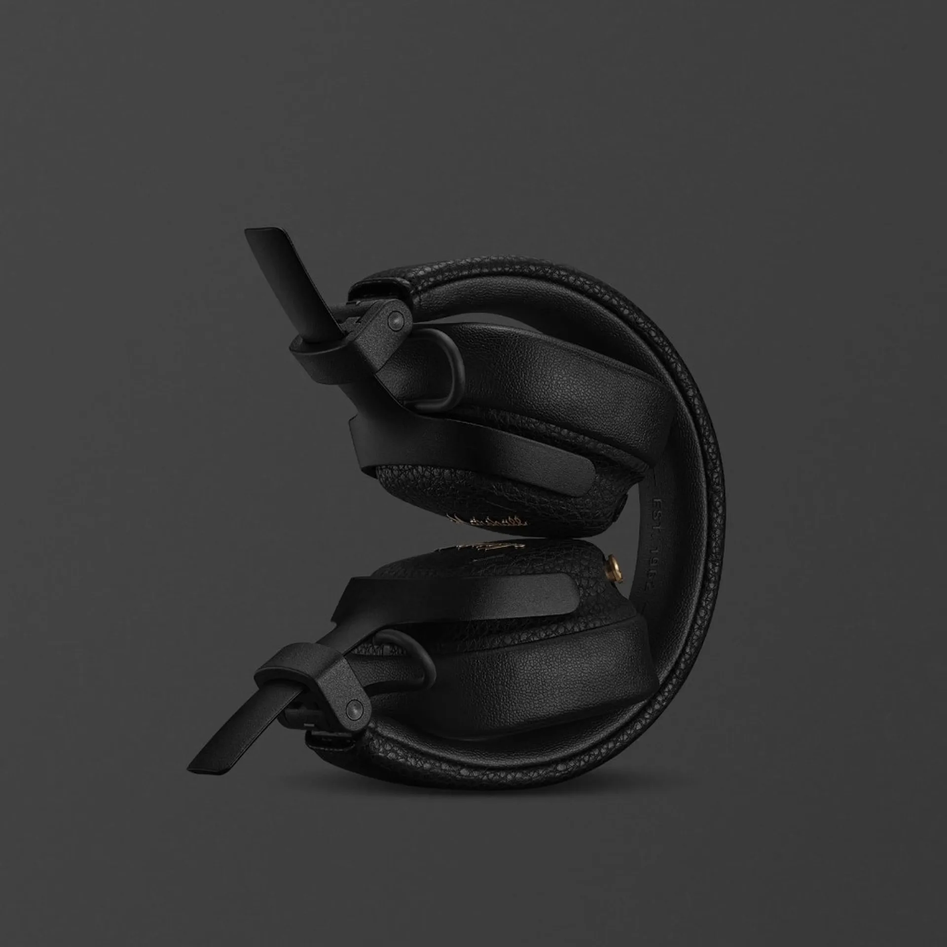 Marshall Milton ANC headphones folded flat showing compact profile, textured leather-look headband with Est. 1962 branding.