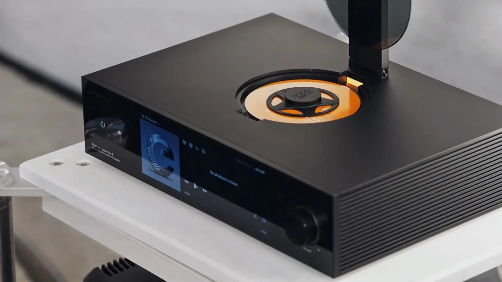 Man adjusting volume knob on Eversolo DMP-A8 Master Edition Gen 2 with touchscreen on a white hi-fi rack.