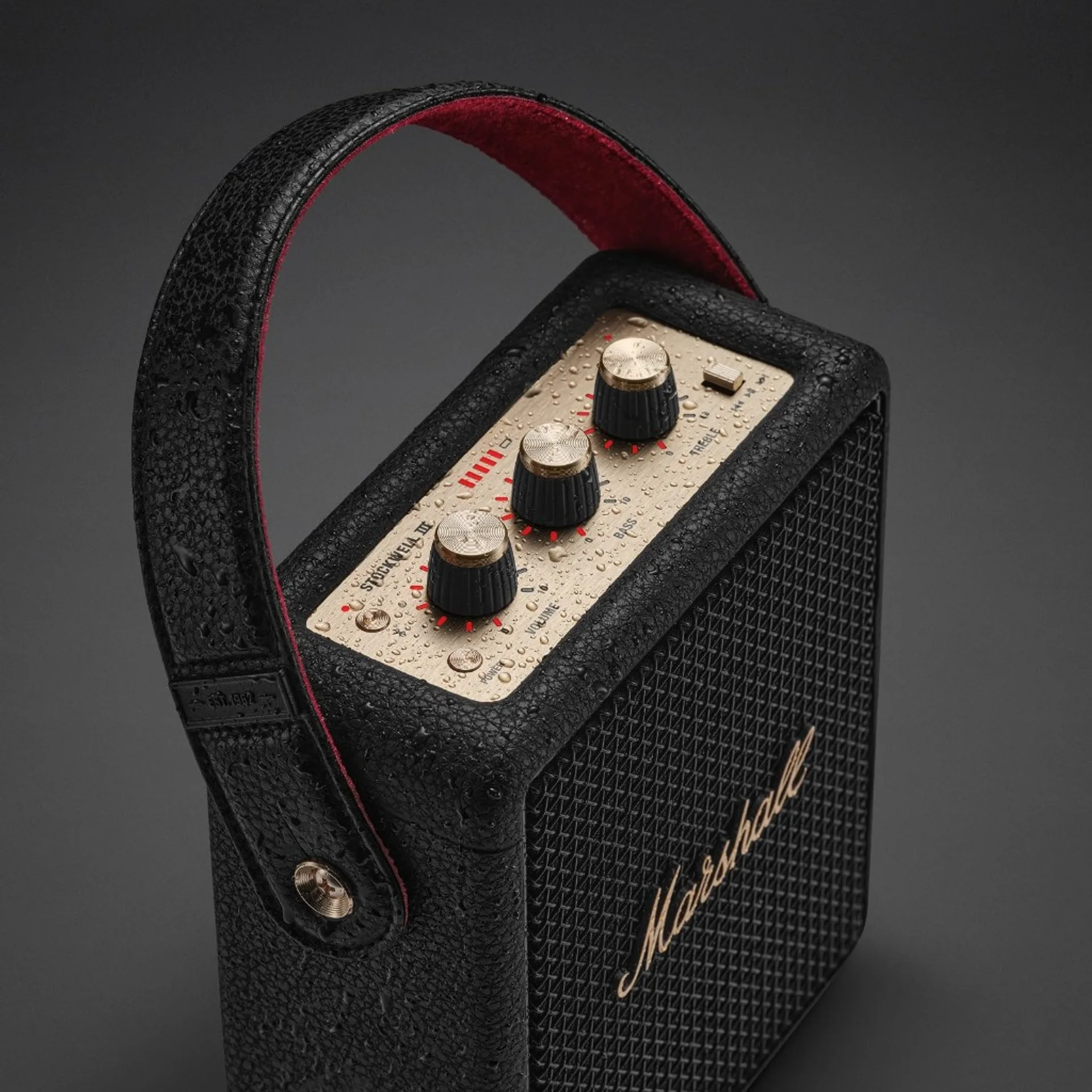 Marshall Stockwell III with water droplets on brass knobs and leather casing highlighting IP55 splash resistance.