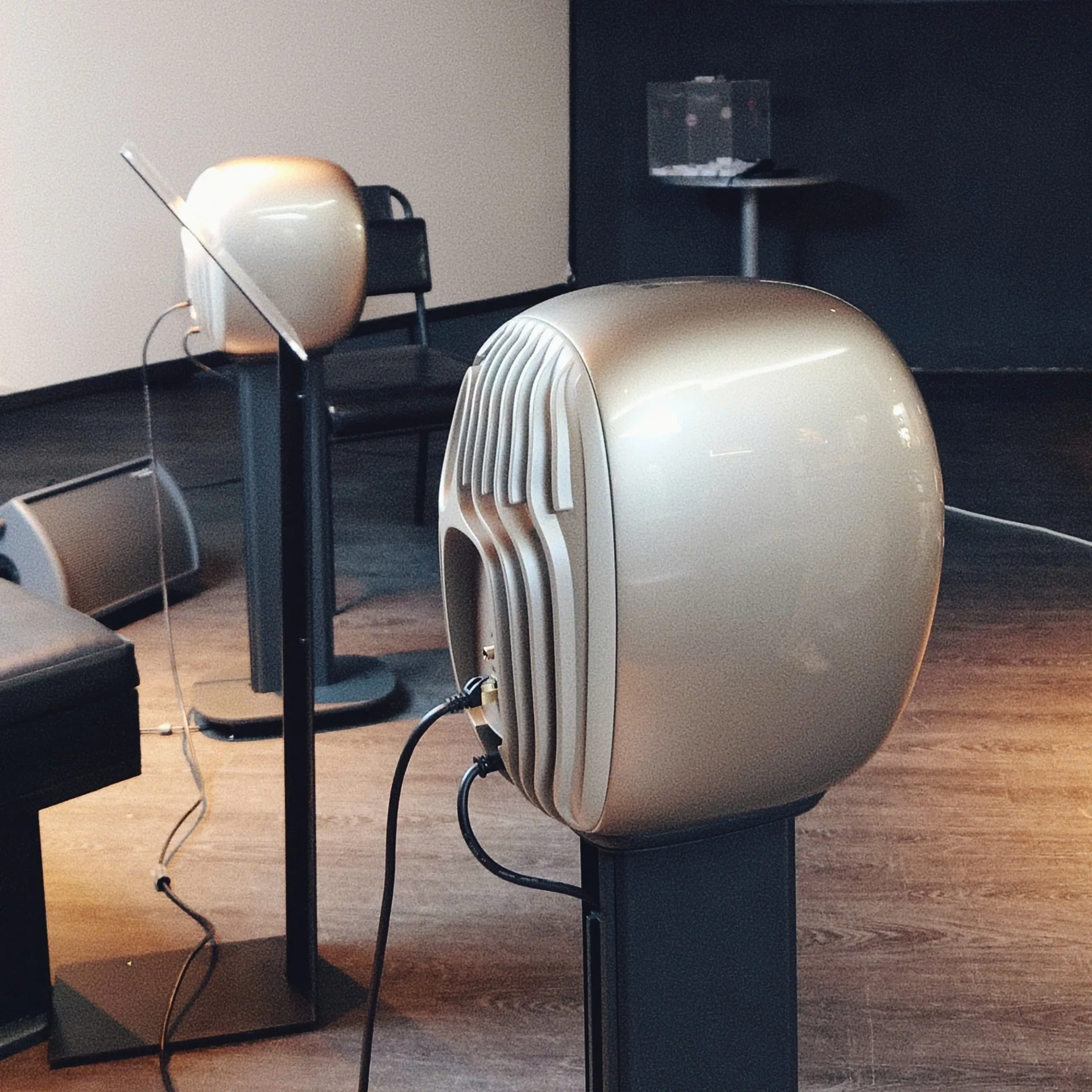 Rear view of KEF LS LUXE pair on black S-LUXE stands showing sculpted cooling fins