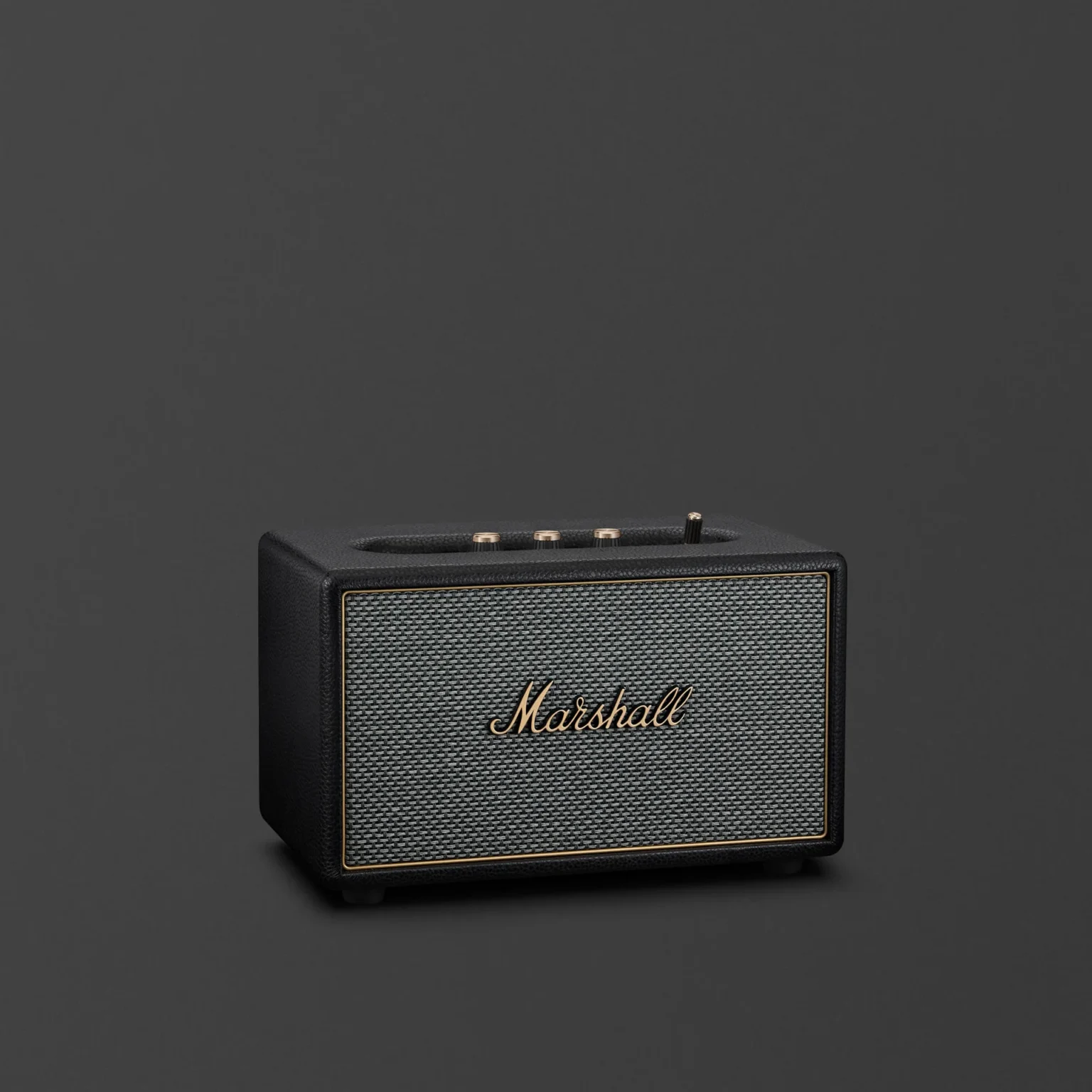Marshall Acton IV Black home Bluetooth speaker with salt-and-pepper grille and brass top controls on dark grey background.