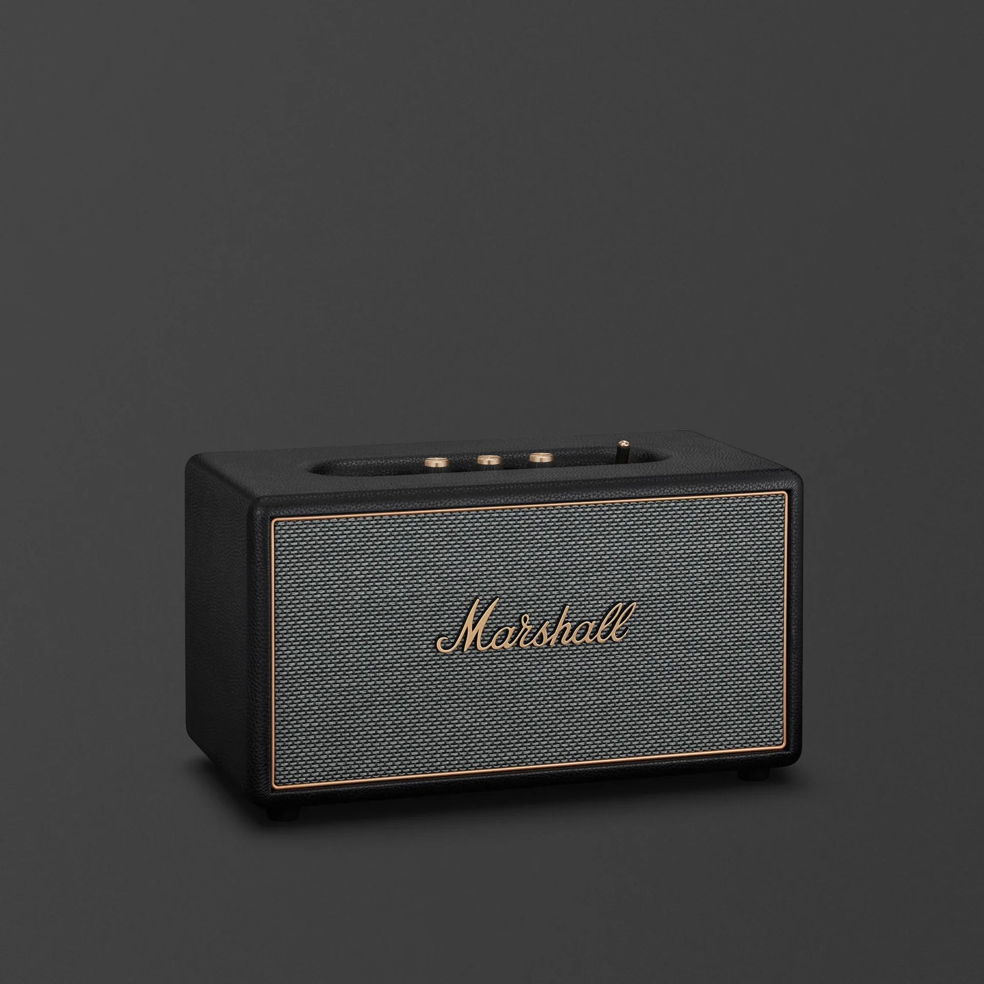 Marshall Stanmore IV Black home Bluetooth speaker with salt-and-pepper grille and brass controls on dark grey background.