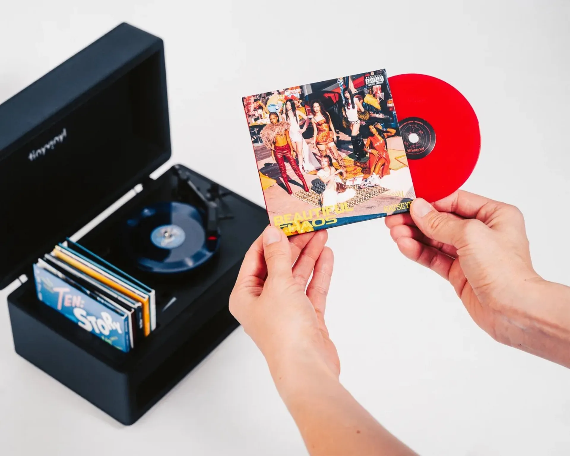 Hand holding a Tiny Vinyl 4-inch record next to packaging