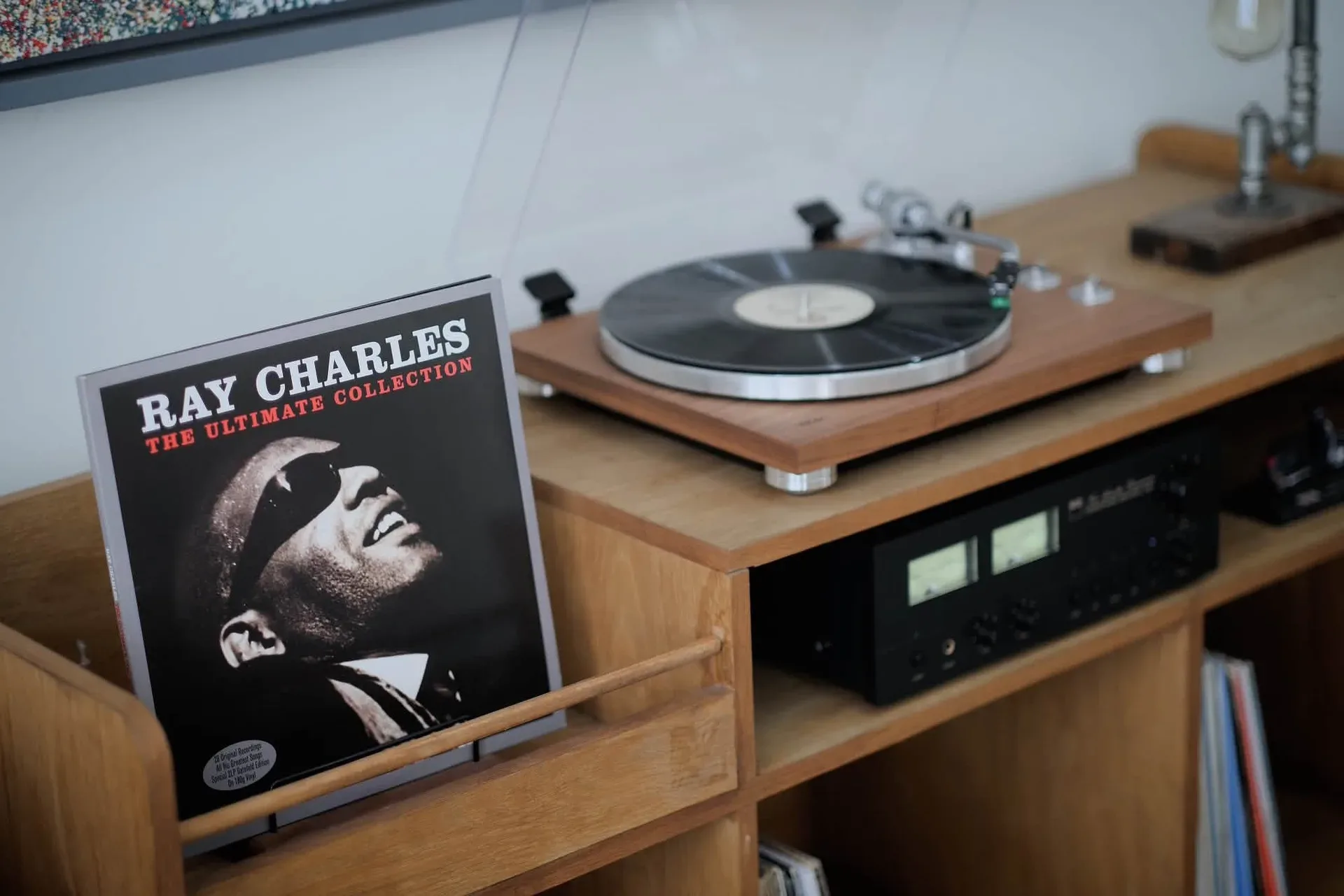 TEAC TN-400BT-X walnut turntable with NAD C 3030 VU meters lit and a vinyl record sleeve