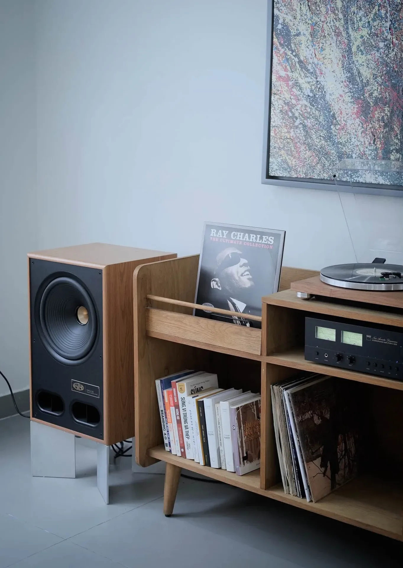Light wood Vestlyd V12C speaker beside NAD C 3030 and TEAC TN-400BT-X on a cabinet with vinyl records